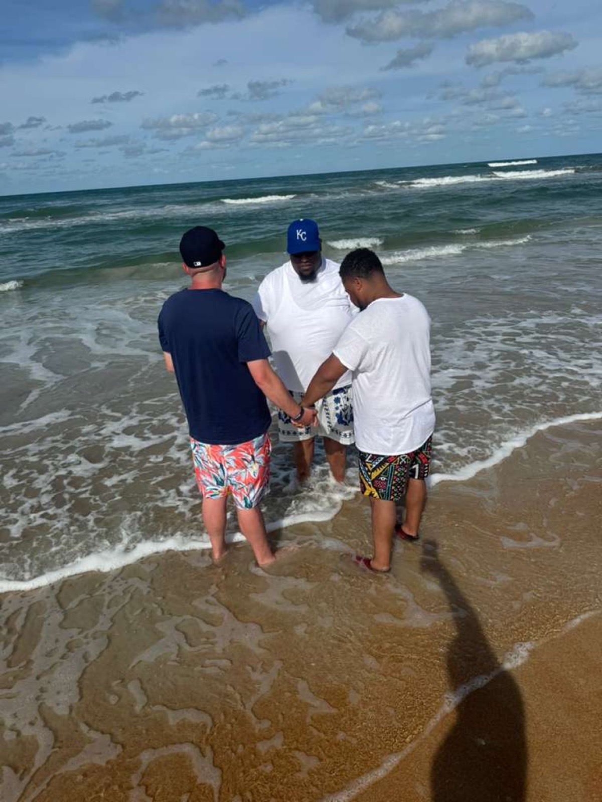 Men's Ministry praying together in the ocean